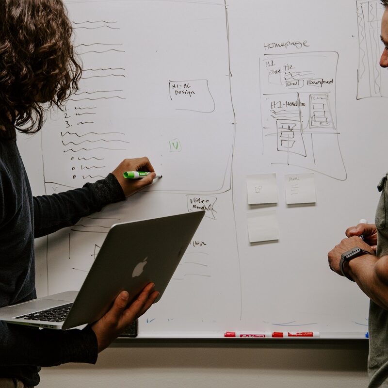 A man and a woman discussing something on the board